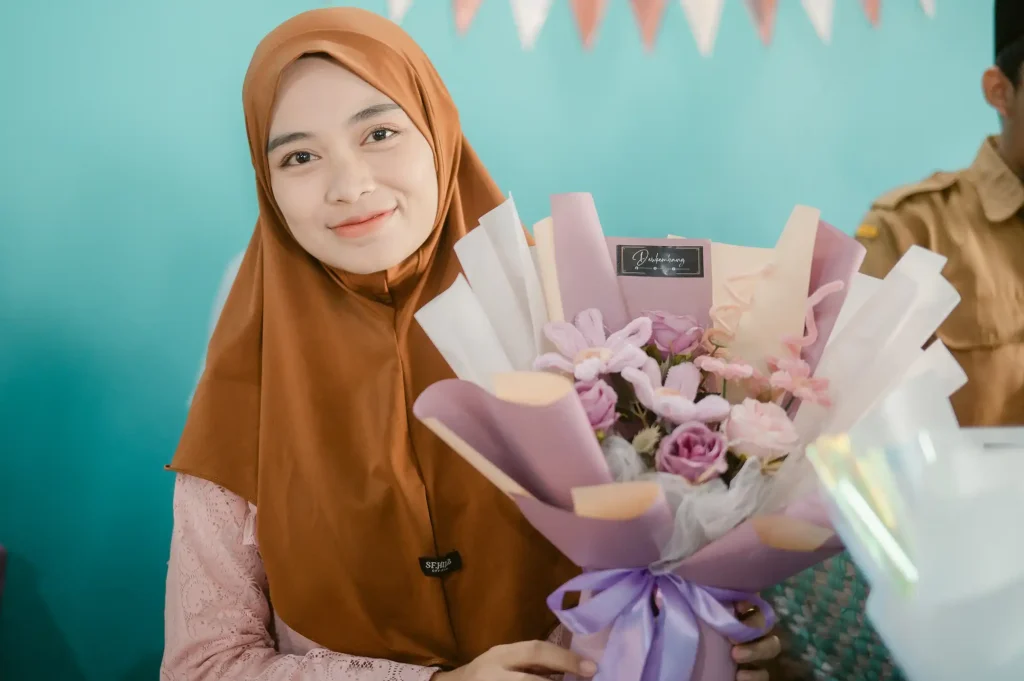 A beneficiary of the SCILLS program in Indonesia displays a flower arrangement she made and now sells online.