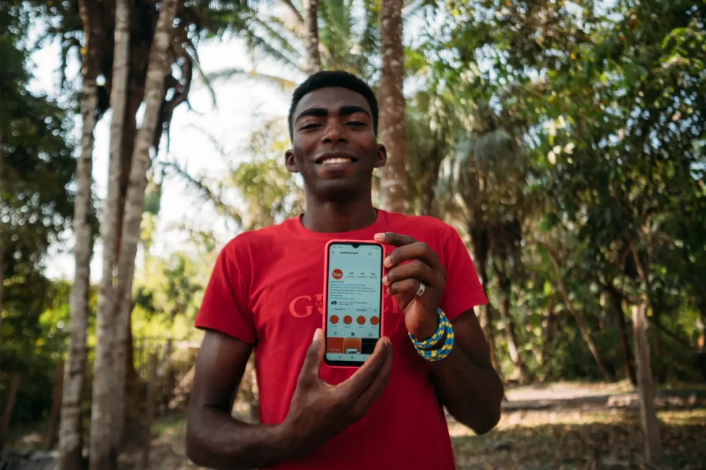 A man from NUPEF holding a phone showing their Instagram profile